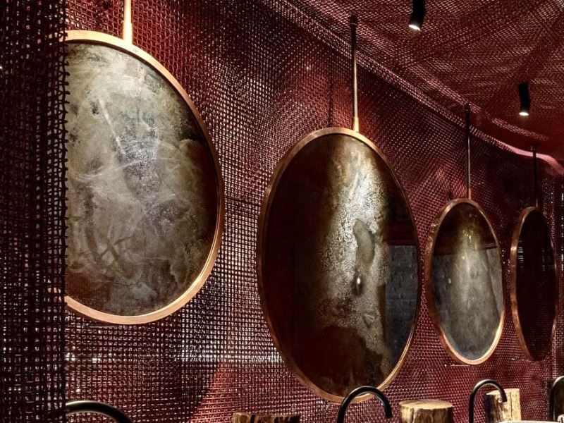 Круглі зістарені дзеркала в металі в ресторані Virgin Izakaia Kyiv